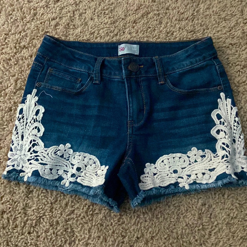 jeans with white floral designs on the edge